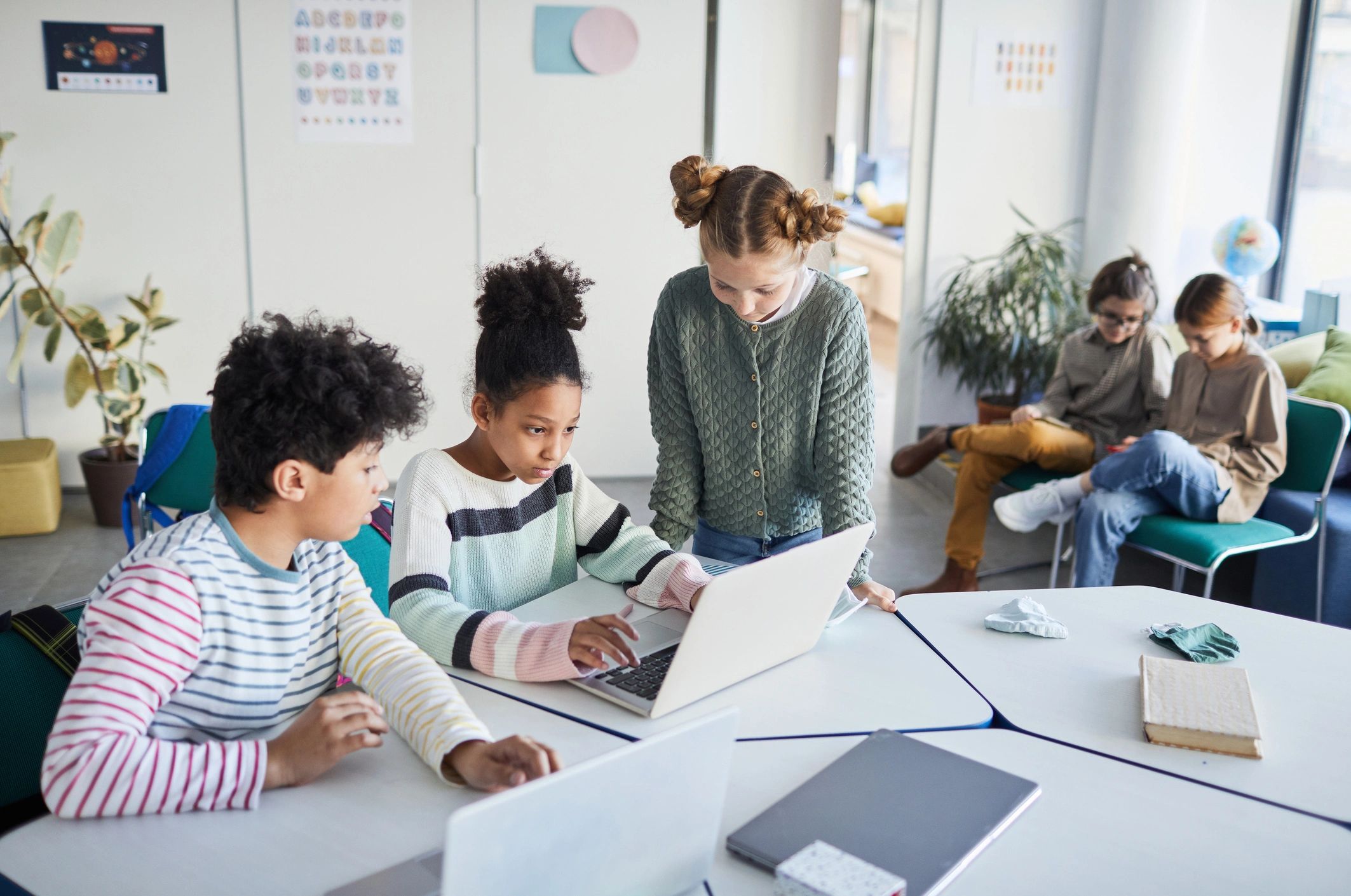 Kids collaborating at a desk in a modern classroom