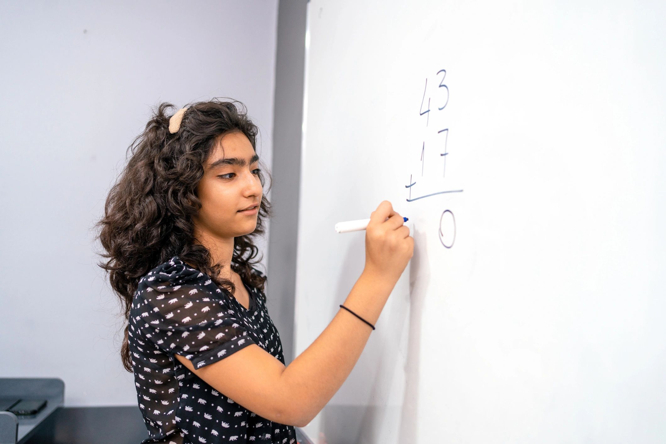 Student solving math problems on a whiteboard