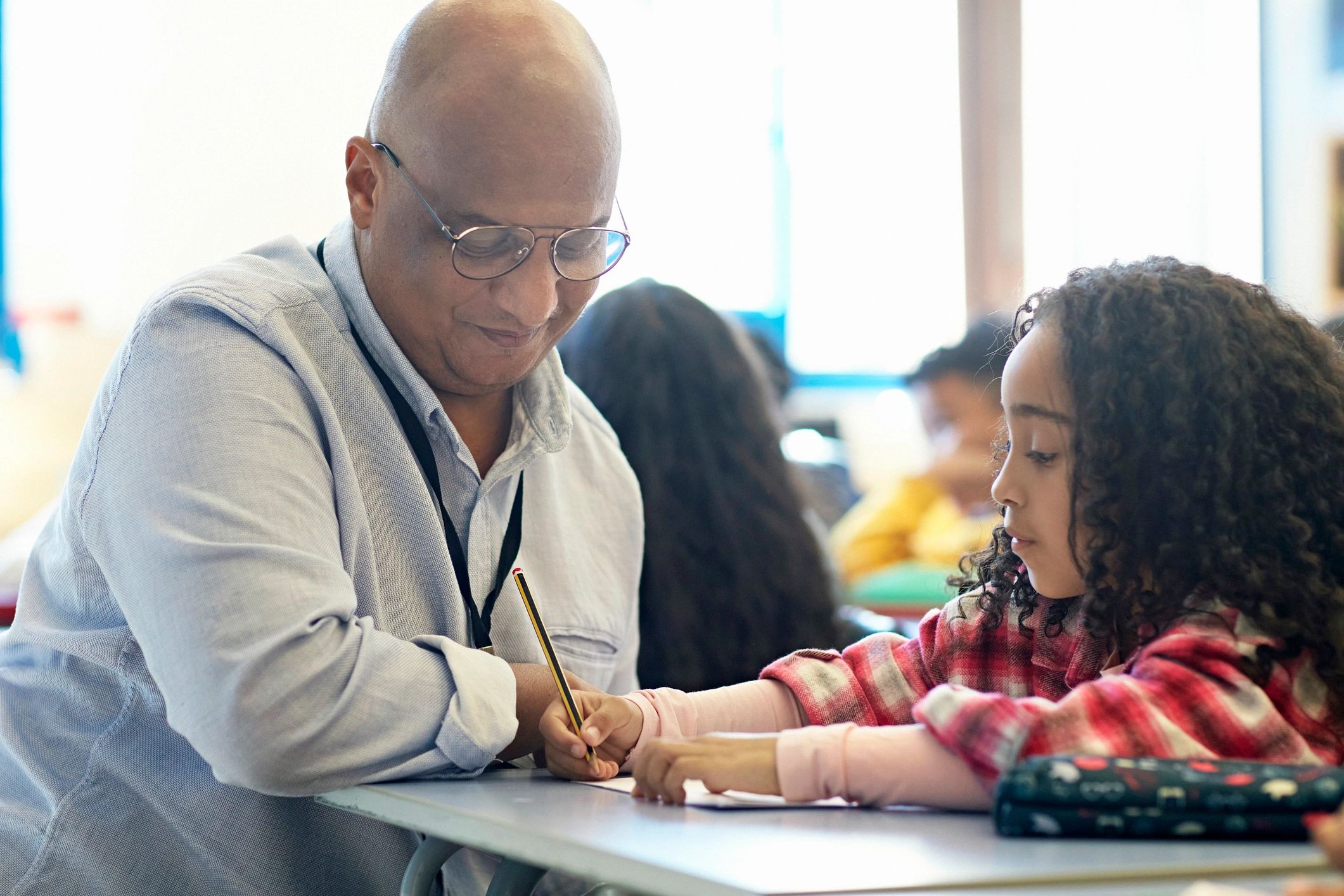 Teacher supporting a student at her desk
