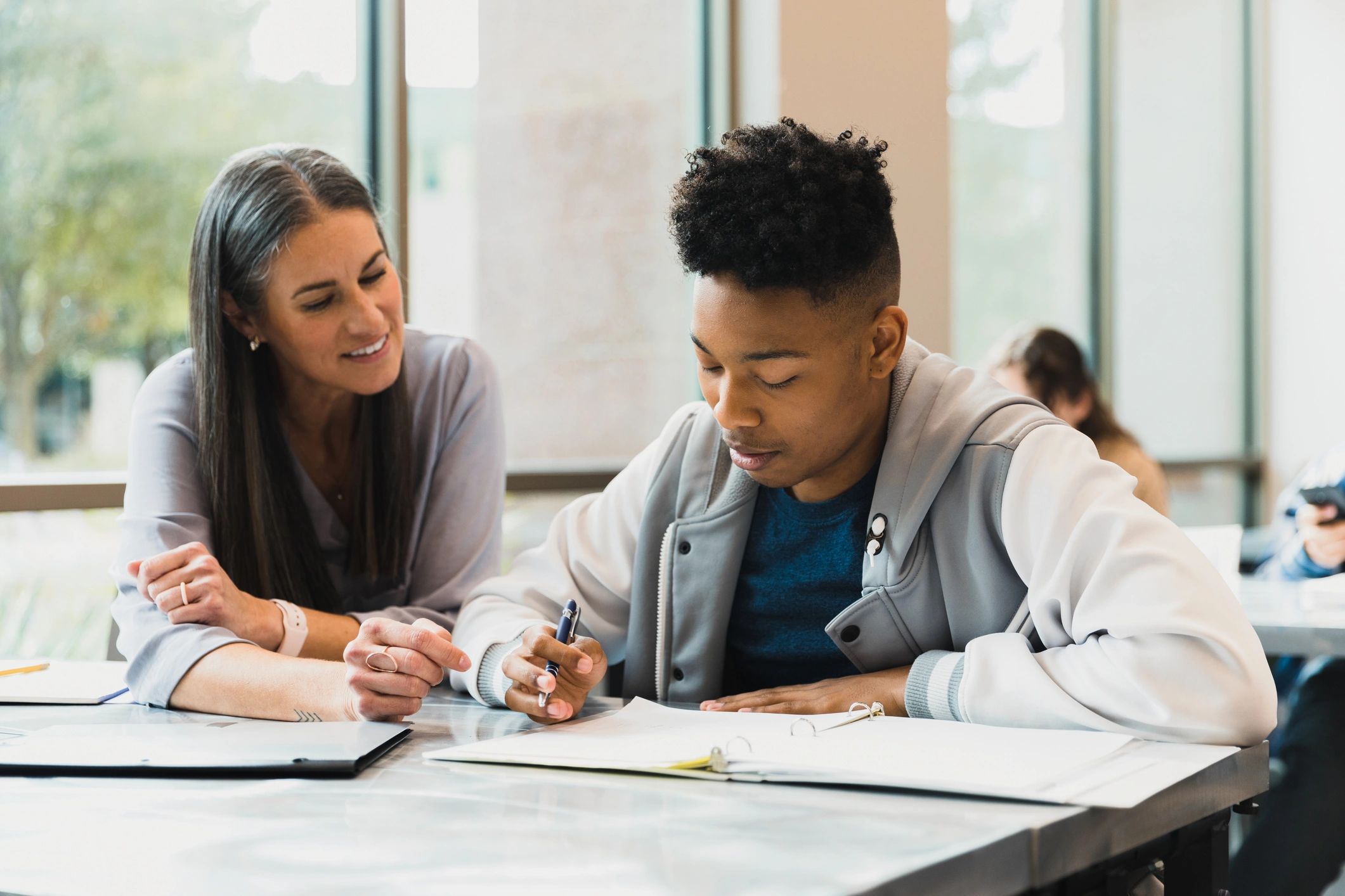 Teacher helping a student with reading and homework