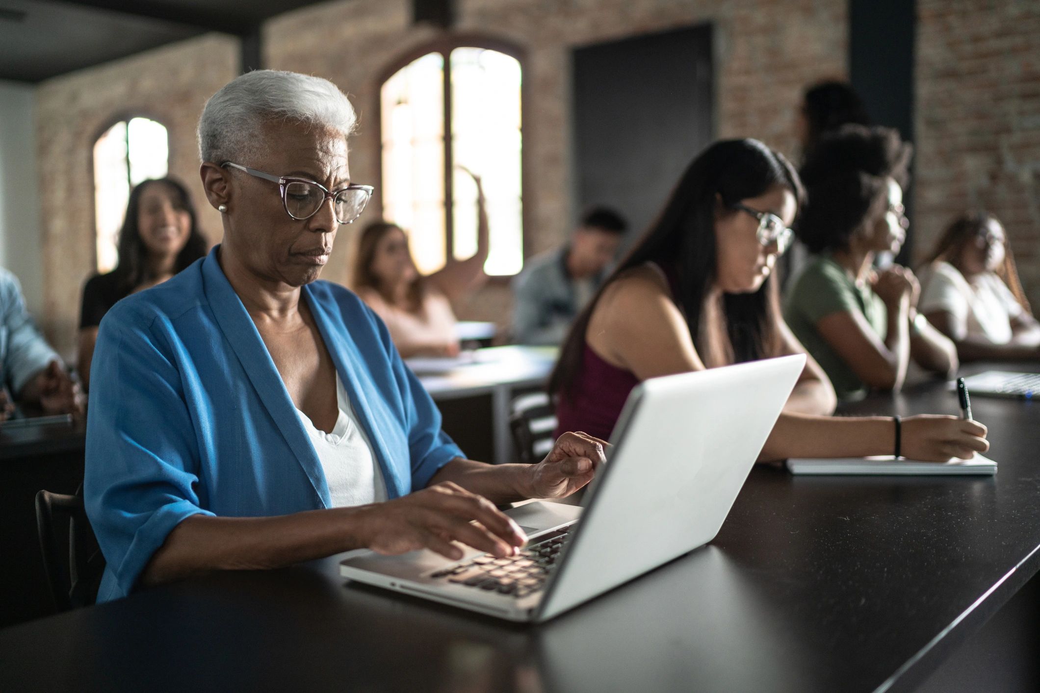 Adult learner using a laptop in a classroom