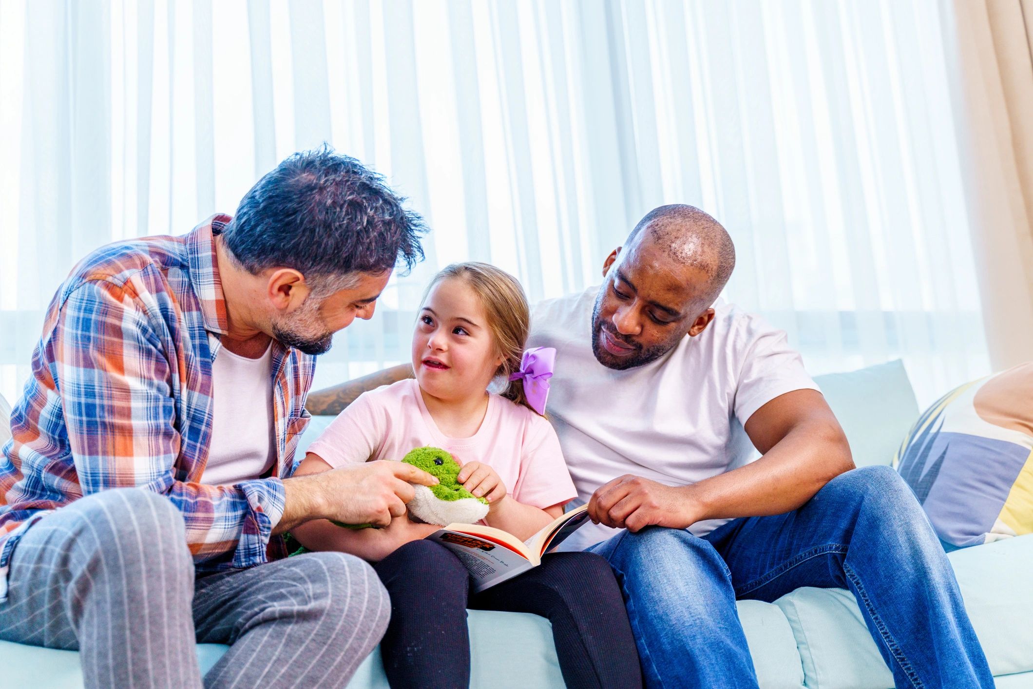 Family reading a book together on a couch