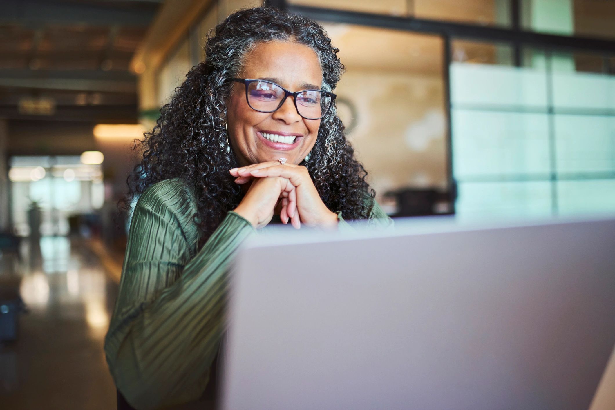 Adult learner smiling during an online lesson on a laptop