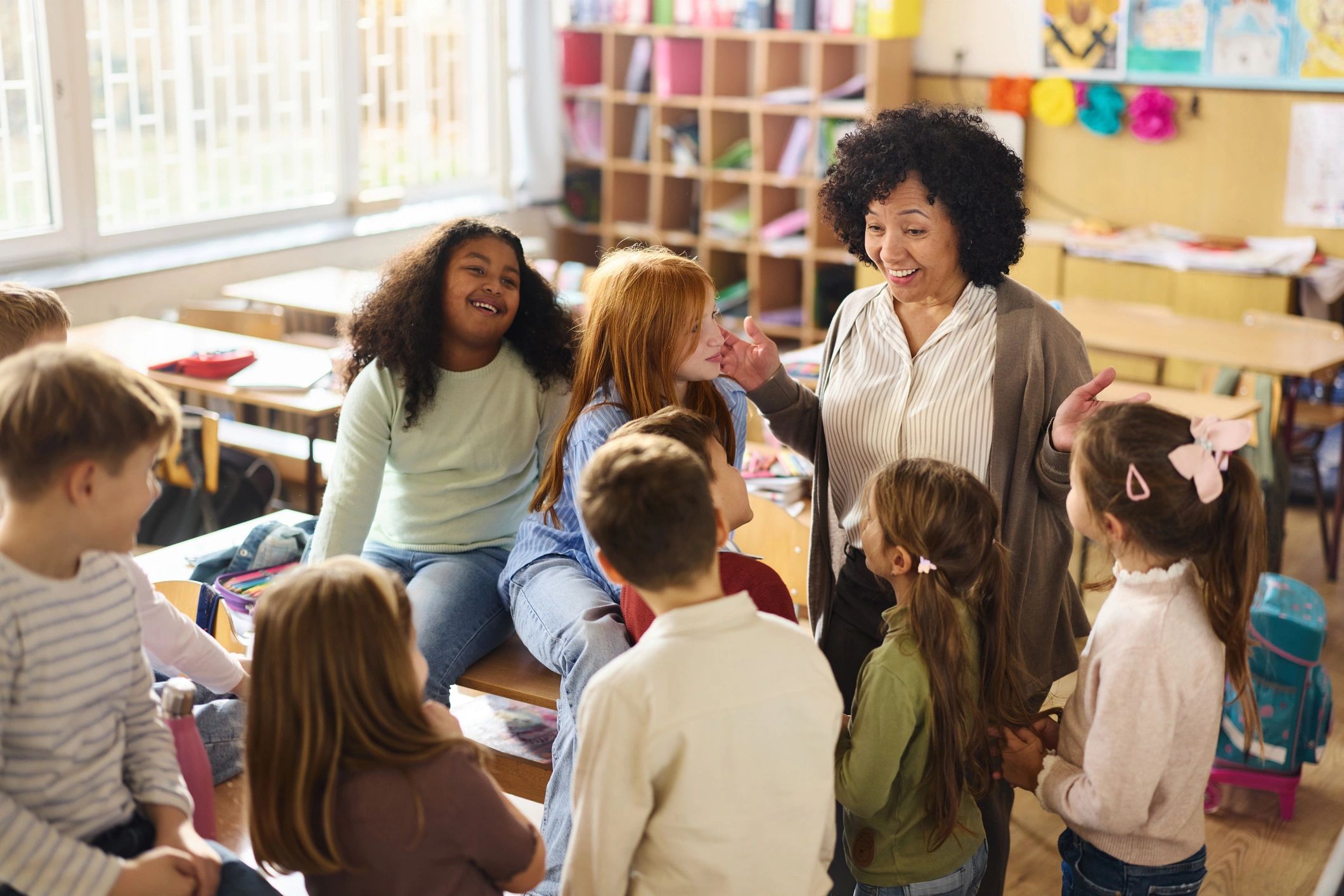 Teacher talking with elementary students in a classroom