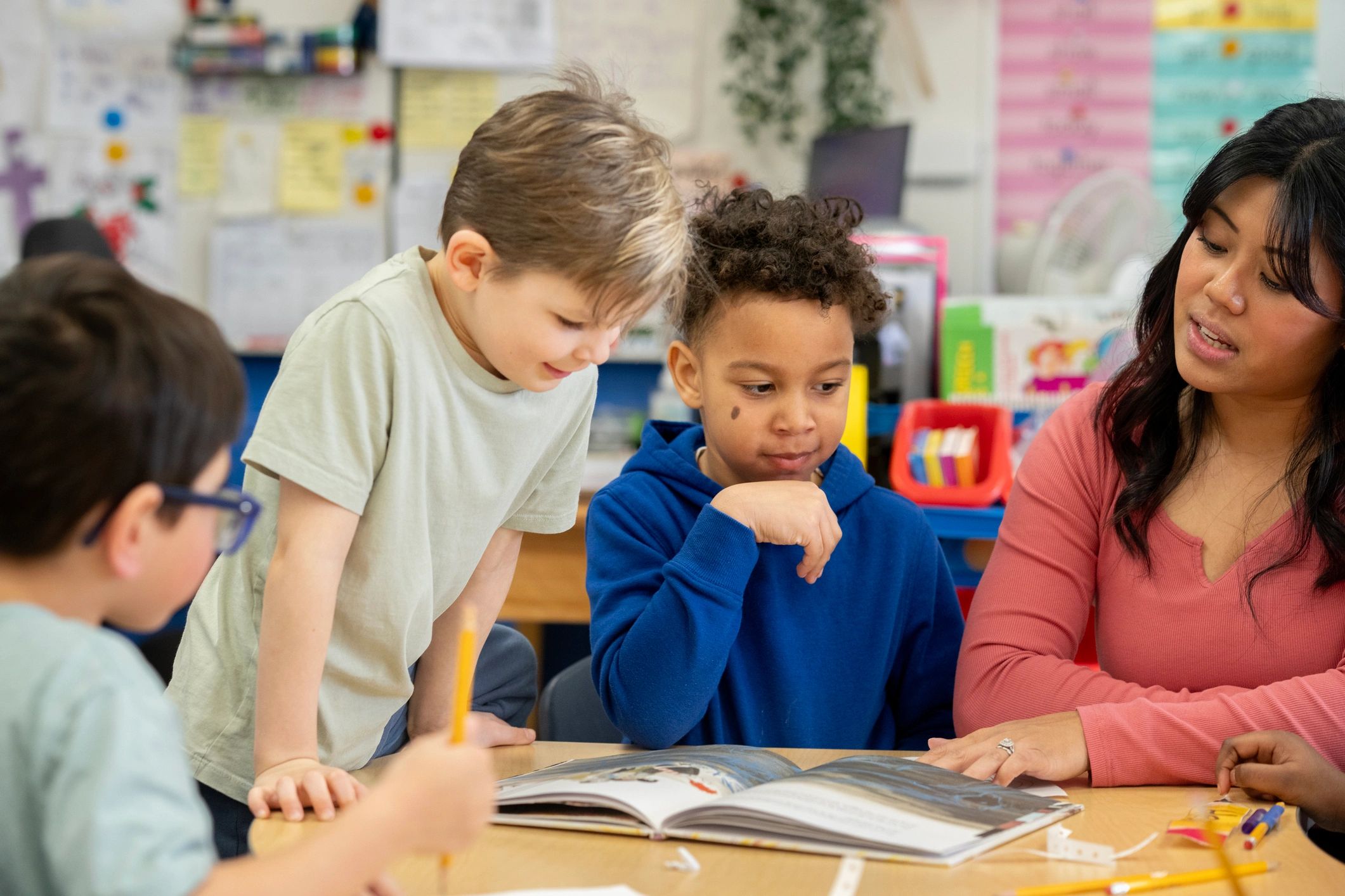 Teacher leading a small-group reading lesson with diverse elementary students