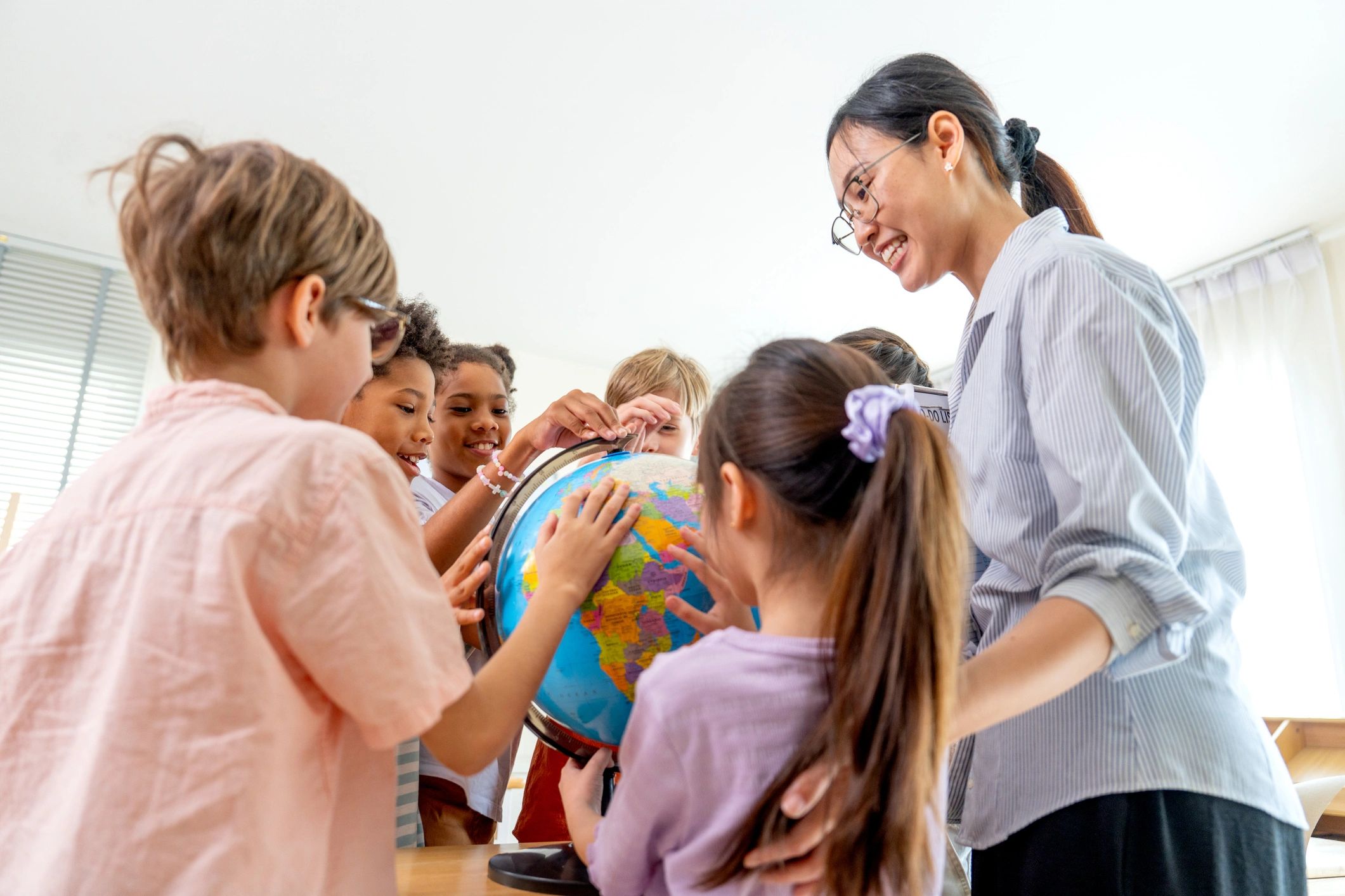 Teacher and kids learning with a globe